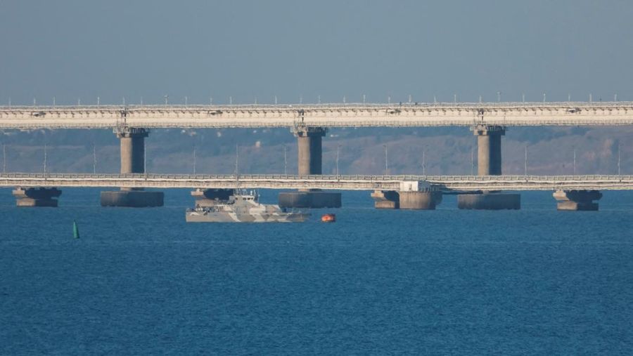 An armed ship sails next to Crimean bridge connecting the Russian mainland with the peninsula across the Kerch Strait, Crimea, July 17, 2023. REUTERS/Stringer