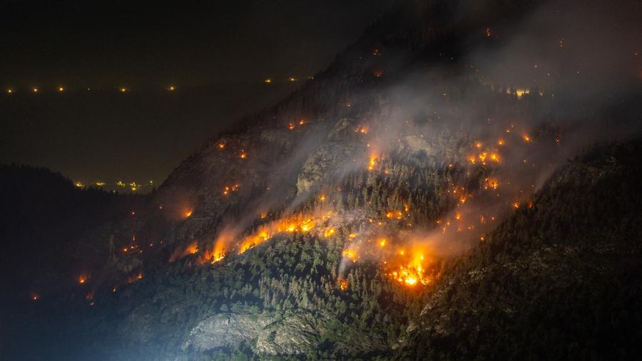 General view of a wildfire on the flank of a mountain in Bitsch near Brig, Switzerland, July 18, 2023. Picture taken with a long exposure. REUTERS/Denis Balibouse