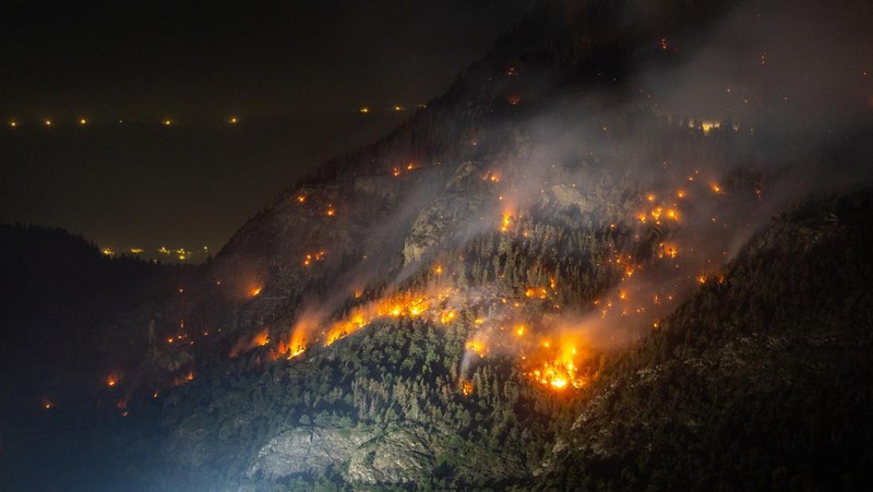 General view of a wildfire on the flank of a mountain in Bitsch near Brig, Switzerland, July 18, 2023. Picture taken with a long exposure. REUTERS/Denis Balibouse