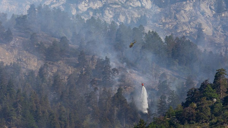 General view of a wildfire on the flank of a mountain in Bitsch near Brig, Switzerland, July 18, 2023. Picture taken with a long exposure. REUTERS/Denis Balibouse