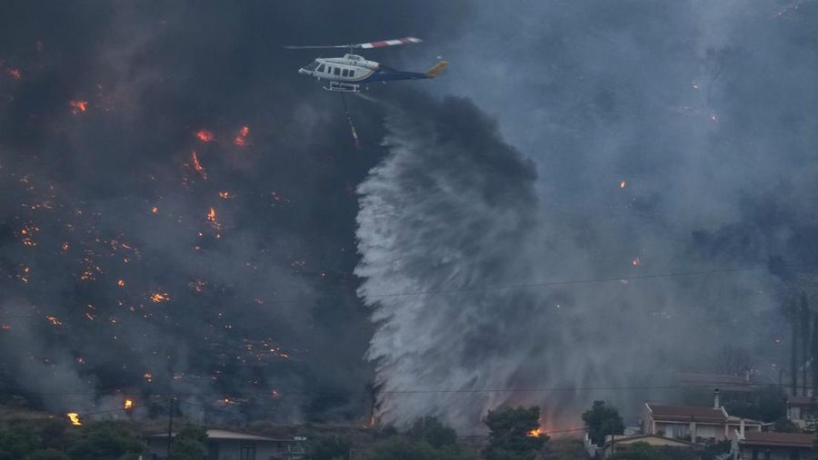 Petugas pemadam kebakaran berusaha memadamkan api yang membakar di Saronida, dekat Athena, Yunani, 17 Juli 2023. (REUTERS/Stelios Misinas)