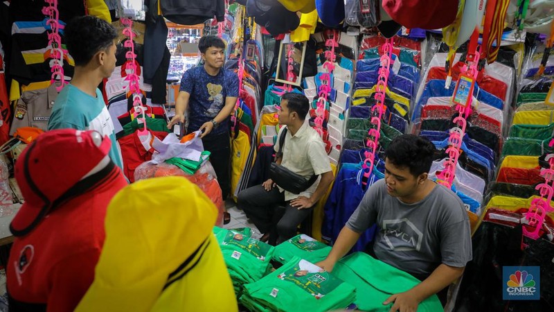 Penjual menata atribut partai di Pasar Senen, Jakarta, Selasa (18/7/2023). Menjelang musim kampanye penjualan atribut partai untuk kampanye di Pasar Senen mulai mengalami peningkatan pesanan. (CNBC Indonesia/Faisal Rahman)