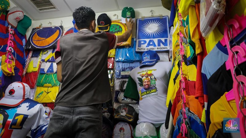 Penjual menata atribut partai di Pasar Senen, Jakarta, Selasa (18/7/2023). Menjelang musim kampanye penjualan atribut partai untuk kampanye di Pasar Senen mulai mengalami peningkatan pesanan. (CNBC Indonesia/Faisal Rahman)