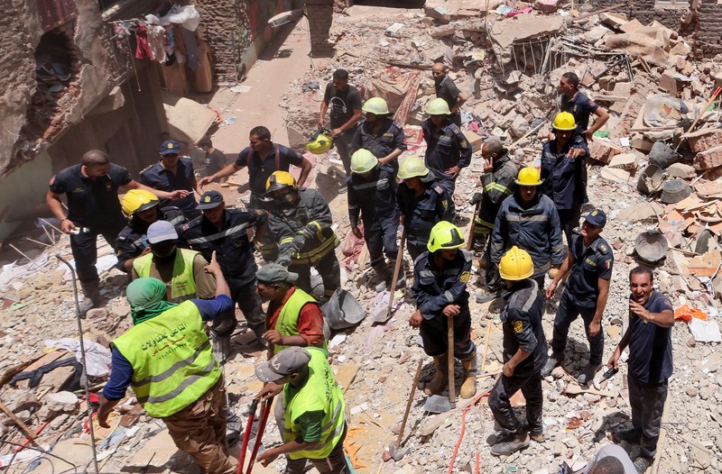 Seorang pria duduk di atas puing-puing menunggu saat petugas darurat dan penyelamat Mesir mencari korban selamat di reruntuhan gedung apartemen berlantai lima yang runtuh, menyebabkan beberapa orang tewas, menurut pihak berwenang, di lingkungan Hadaeq al-Qubbah, di Kairo, Mesir, 17 Juli 2023. (REUTERS/Mohamed Abd El Ghany)