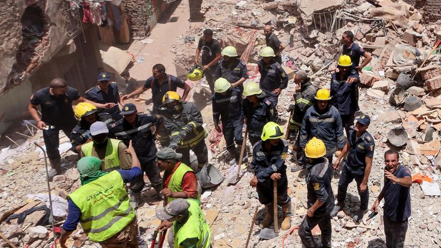 Seorang pria duduk di atas puing-puing menunggu saat petugas darurat dan penyelamat Mesir mencari korban selamat di reruntuhan gedung apartemen berlantai lima yang runtuh, menyebabkan beberapa orang tewas, menurut pihak berwenang, di lingkungan Hadaeq al-Qubbah, di Kairo, Mesir, 17 Juli 2023. (REUTERS/Mohamed Abd El Ghany)