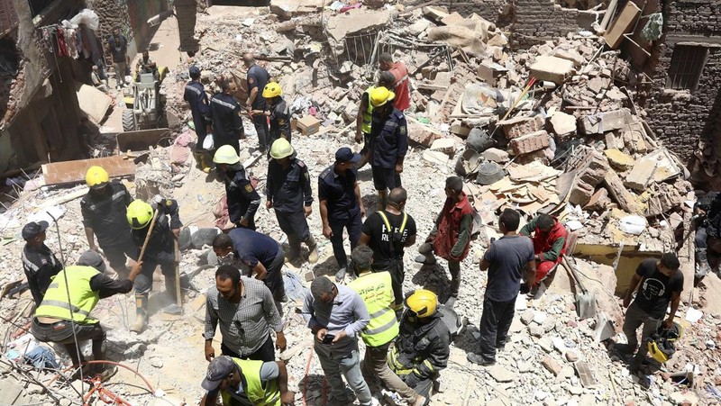Seorang pria duduk di atas puing-puing menunggu saat petugas darurat dan penyelamat Mesir mencari korban selamat di reruntuhan gedung apartemen berlantai lima yang runtuh, menyebabkan beberapa orang tewas, menurut pihak berwenang, di lingkungan Hadaeq al-Qubbah, di Kairo, Mesir, 17 Juli 2023. (REUTERS/Mohamed Abd El Ghany)