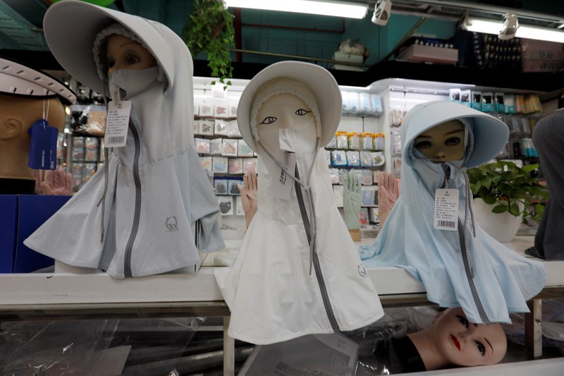 Sejumlah Manekin dikenakan penutup kepala pelindung matahari terlihat dipajang di sebuah toko di pusat perbelanjaan, di tengah peringatan kuning gelombang panas di Beijing, China, 19 Juli 2023. (REUTERS/Florence Lo)
