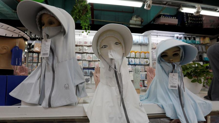 Sejumlah Manekin dikenakan penutup kepala pelindung matahari terlihat dipajang di sebuah toko di pusat perbelanjaan, di tengah peringatan kuning gelombang panas di Beijing, China, 19 Juli 2023. (REUTERS/Florence Lo)