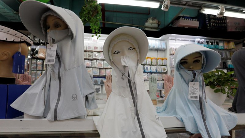 Sejumlah Manekin dikenakan penutup kepala pelindung matahari terlihat dipajang di sebuah toko di pusat perbelanjaan, di tengah peringatan kuning gelombang panas di Beijing, China, 19 Juli 2023. (REUTERS/Florence Lo)