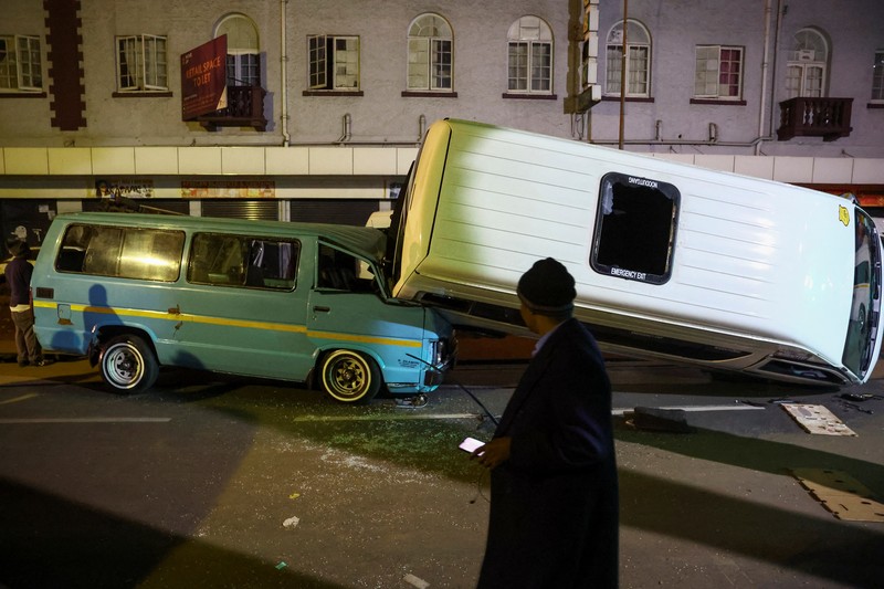 Petugas polisi memeriksa mobil yang rusak dan jalan setelah ledakan gas yang diduga melukai orang dan menyebabkan kerusakan yang signifikan, di distrik pusat bisnis Johannesburg, Afrika Selatan 19 Juli 2023. Petugas polisi memeriksa mobil yang rusak dan jalan setelah ledakan gas yang diduga melukai orang dan menyebabkan kerusakan yang signifikan, di distrik pusat bisnis Johannesburg, Afrika Selatan 19 Juli 2023. (REUTERS/Siphiwe Sibeko)