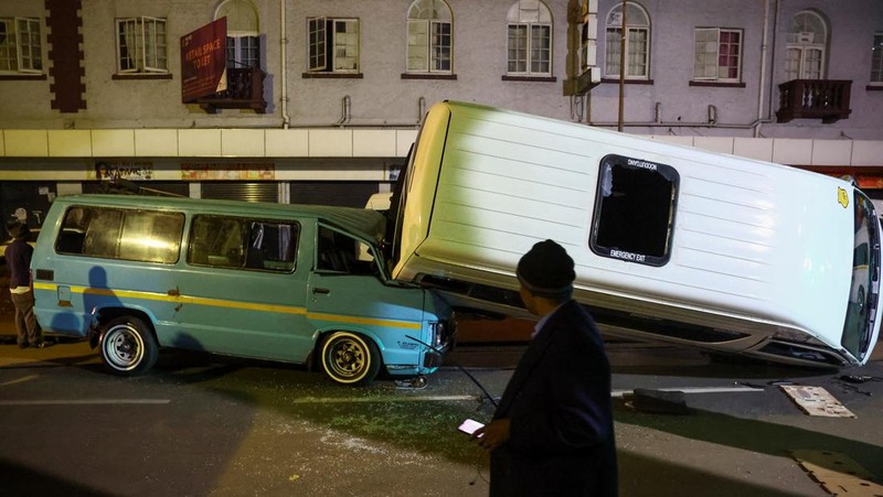 Petugas polisi memeriksa mobil yang rusak dan jalan setelah ledakan gas yang diduga melukai orang dan menyebabkan kerusakan yang signifikan, di distrik pusat bisnis Johannesburg, Afrika Selatan 19 Juli 2023. (REUTERS/Siphiwe Sibeko)