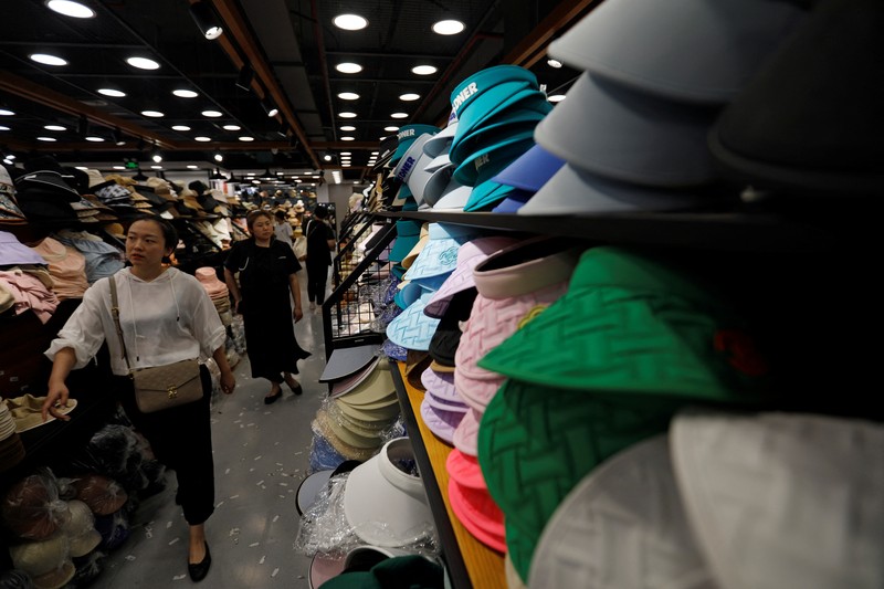 Sejumlah Manekin dikenakan penutup kepala pelindung matahari terlihat dipajang di sebuah toko di pusat perbelanjaan, di tengah peringatan kuning gelombang panas di Beijing, China, 19 Juli 2023. (REUTERS/Florence Lo)