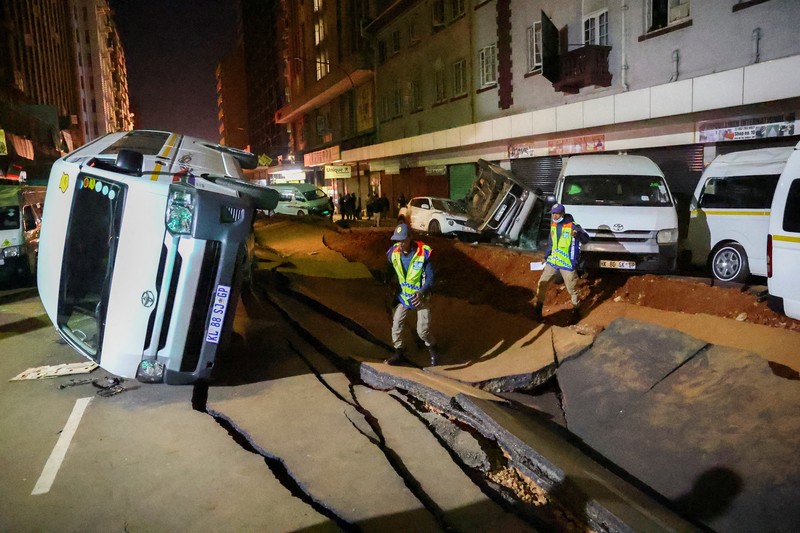 Petugas polisi memeriksa mobil yang rusak dan jalan setelah ledakan gas yang diduga melukai orang dan menyebabkan kerusakan yang signifikan, di distrik pusat bisnis Johannesburg, Afrika Selatan 19 Juli 2023. (REUTERS/Siphiwe Sibeko)
