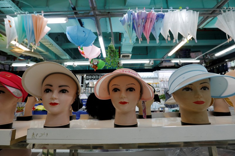 Sejumlah Manekin dikenakan penutup kepala pelindung matahari terlihat dipajang di sebuah toko di pusat perbelanjaan, di tengah peringatan kuning gelombang panas di Beijing, China, 19 Juli 2023. (REUTERS/Florence Lo)