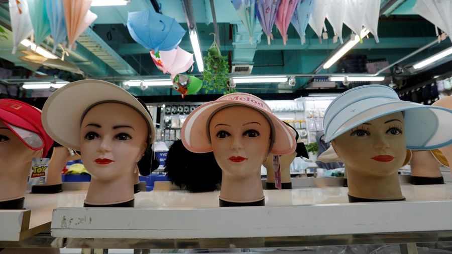 Sejumlah Manekin dikenakan penutup kepala pelindung matahari terlihat dipajang di sebuah toko di pusat perbelanjaan, di tengah peringatan kuning gelombang panas di Beijing, China, 19 Juli 2023. (REUTERS/Florence Lo)