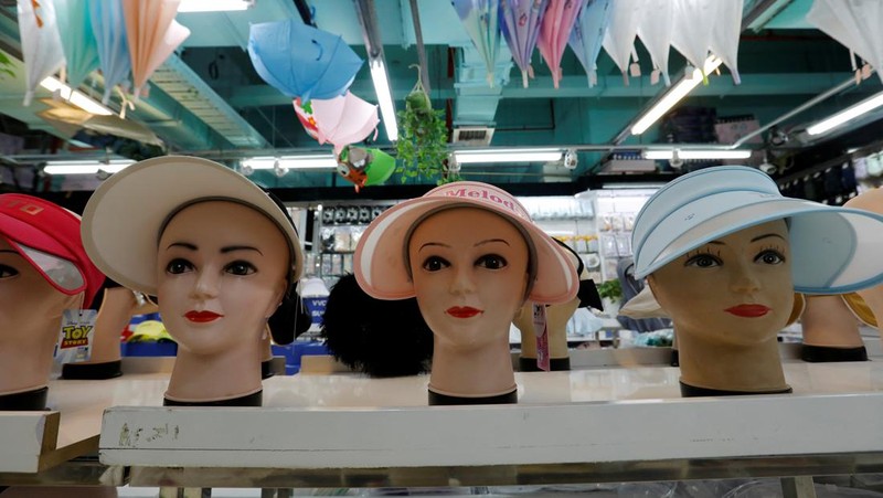 Sejumlah Manekin dikenakan penutup kepala pelindung matahari terlihat dipajang di sebuah toko di pusat perbelanjaan, di tengah peringatan kuning gelombang panas di Beijing, China, 19 Juli 2023. (REUTERS/Florence Lo)
