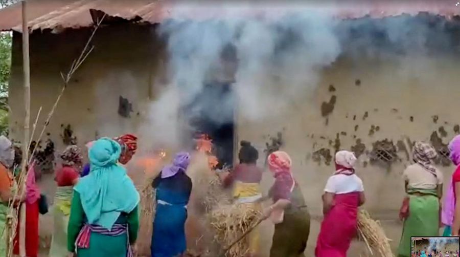 Women put burning hays in house of the accused in viral Manipur video case, in Pechi Awang Leikai, Manipur, India, July 20, 2023, in this screengrab obtained from a Handout video. ANI/via REUTERS INDIA OUT. NO COMMERCIAL OR EDITORIAL SALES IN INDIA. THIS IMAGE HAS BEEN SUPPLIED BY A THIRD PARTY.