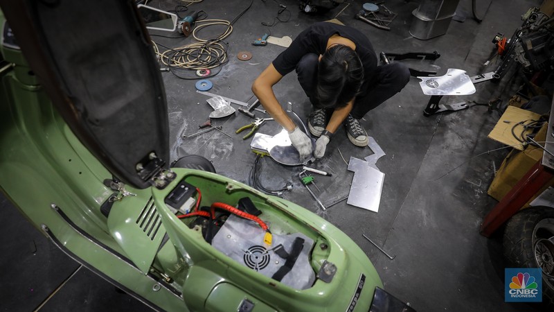 Mekanik mengkonversi vespa klasik dengan bahan bakar minyak (BBM) menjadi vespa tenaga istrik di bengkel Elders Garage, Jakarta, Jumat (21/7/2023).  (CNBC Indonesia/Faisal Rahman)