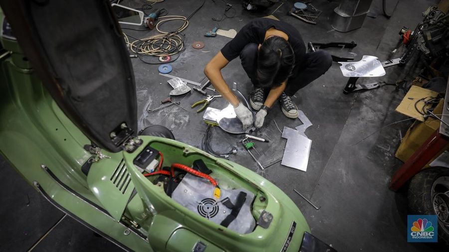 Mekanik mengkonversi vespa klasik dengan bahan bakar minyak (BBM) menjadi vespa tenaga istrik di bengkel Elders Garage, Jakarta, Jumat (21/7/2023).  (CNBC Indonesia/Faisal Rahman)