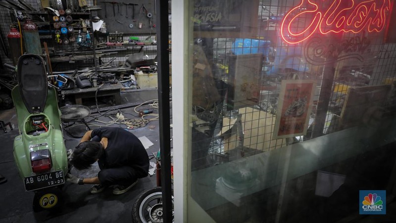 Mekanik mengkonversi vespa klasik dengan bahan bakar minyak (BBM) menjadi vespa tenaga istrik di bengkel Elders Garage, Jakarta, Jumat (21/7/2023).  (CNBC Indonesia/Faisal Rahman)