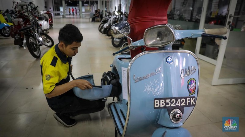 Mekanik mengkonversi vespa klasik dengan bahan bakar minyak (BBM) menjadi vespa tenaga istrik di bengkel Elders Garage, Jakarta, Jumat (21/7/2023).  (CNBC Indonesia/Faisal Rahman)
