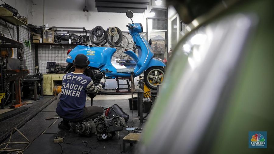 Mekanik mengkonversi vespa klasik dengan bahan bakar minyak (BBM) menjadi vespa tenaga istrik di bengkel Elders Garage, Jakarta, Jumat (21/7/2023).  (CNBC Indonesia/Faisal Rahman)