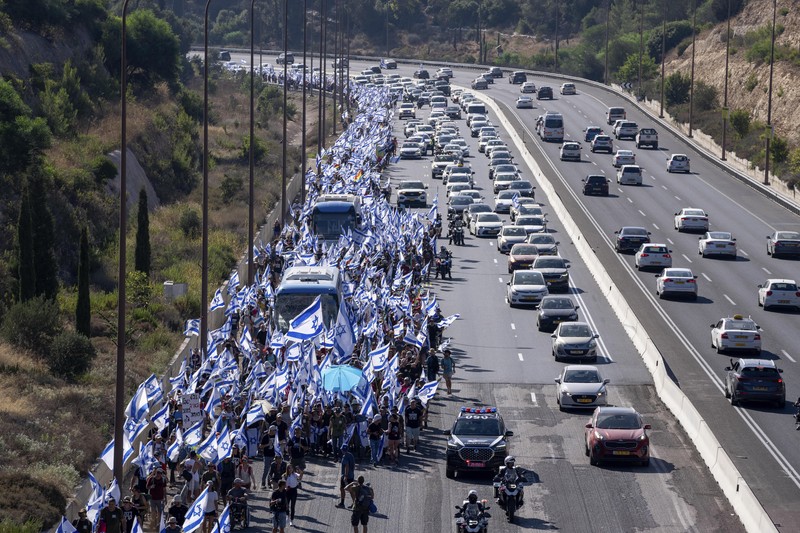 Orang-orang Israel berbaris di sepanjang Highway 1 dalam perjalanan mereka ke Yerusalem dekat Moshav Shoresh di Israel, sebagai bagian dari protes terhadap rencana pemerintah Perdana Menteri Benjamin Netanyahu untuk merombak sistem peradilan, Jumat, 21 Juli 2023 waktu setempat. (AP/Ohad Zwigenberg) Orang-orang Israel berbaris di sepanjang Highway 1 dalam perjalanan mereka ke Yerusalem dekat Moshav Shoresh di Israel, sebagai bagian dari protes terhadap rencana pemerintah Perdana Menteri Benjamin Netanyahu untuk merombak sistem peradilan, Jumat, 21 Juli 2023 waktu setempat. (AP/Ohad Zwigenberg)