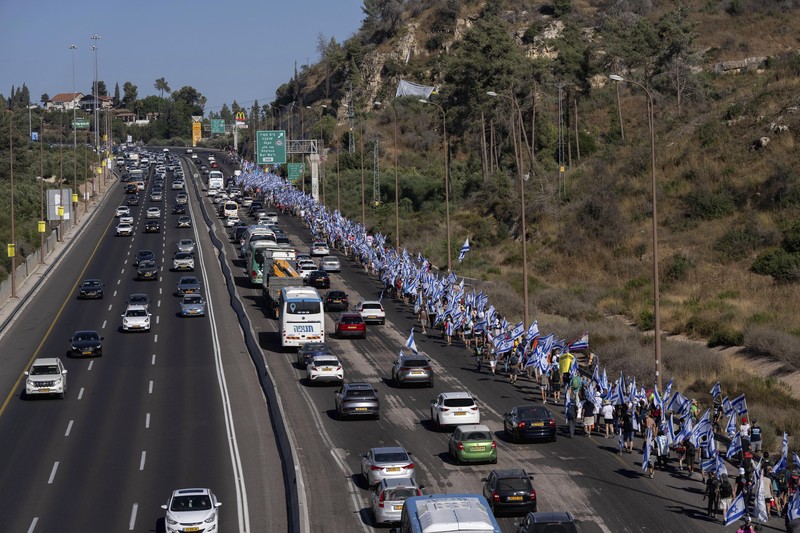 Orang-orang Israel berbaris di sepanjang Highway 1 dalam perjalanan mereka ke Yerusalem dekat Moshav Shoresh di Israel, sebagai bagian dari protes terhadap rencana pemerintah Perdana Menteri Benjamin Netanyahu untuk merombak sistem peradilan, Jumat, 21 Juli 2023 waktu setempat. (AP/Ohad Zwigenberg) Orang-orang Israel berbaris di sepanjang Highway 1 dalam perjalanan mereka ke Yerusalem dekat Moshav Shoresh di Israel, sebagai bagian dari protes terhadap rencana pemerintah Perdana Menteri Benjamin Netanyahu untuk merombak sistem peradilan, Jumat, 21 Juli 2023 waktu setempat. (AP/Ohad Zwigenberg)