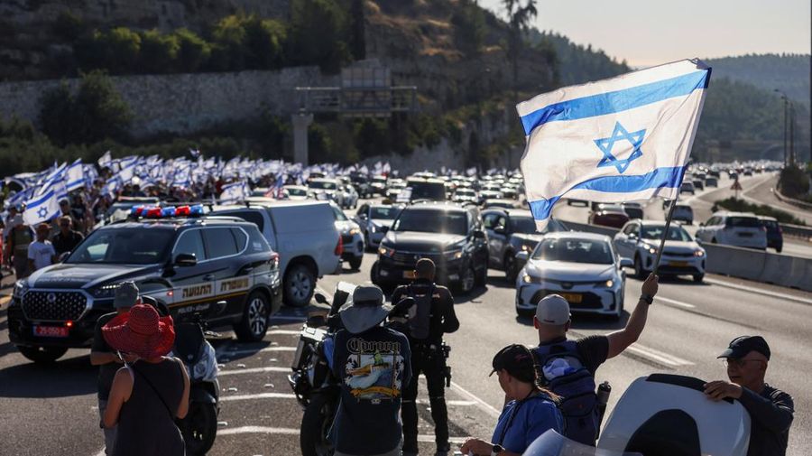 Orang-orang Israel berbaris di sepanjang Highway 1 dalam perjalanan mereka ke Yerusalem dekat Moshav Shoresh di Israel, sebagai bagian dari protes terhadap rencana pemerintah Perdana Menteri Benjamin Netanyahu untuk merombak sistem peradilan, Jumat, 21 Juli 2023 waktu setempat. (REUTERS/RONEN ZVULUN)