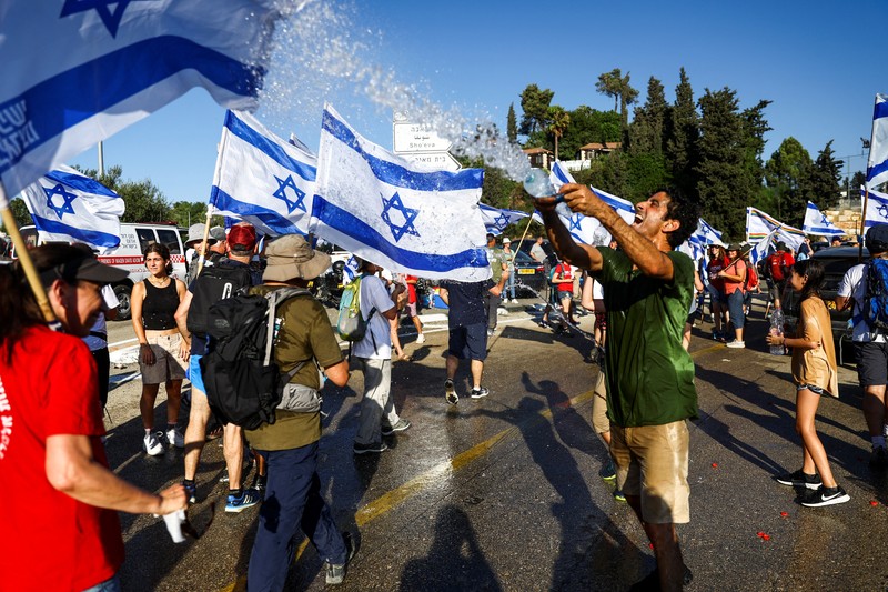 Orang-orang Israel berbaris di sepanjang Highway 1 dalam perjalanan mereka ke Yerusalem dekat Moshav Shoresh di Israel, sebagai bagian dari protes terhadap rencana pemerintah Perdana Menteri Benjamin Netanyahu untuk merombak sistem peradilan, Jumat, 21 Juli 2023 waktu setempat. (AP/Ohad Zwigenberg)