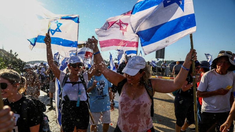Orang-orang Israel berbaris di sepanjang Highway 1 dalam perjalanan mereka ke Yerusalem dekat Moshav Shoresh di Israel, sebagai bagian dari protes terhadap rencana pemerintah Perdana Menteri Benjamin Netanyahu untuk merombak sistem peradilan, Jumat, 21 Juli 2023 waktu setempat. (AP/Ohad Zwigenberg)