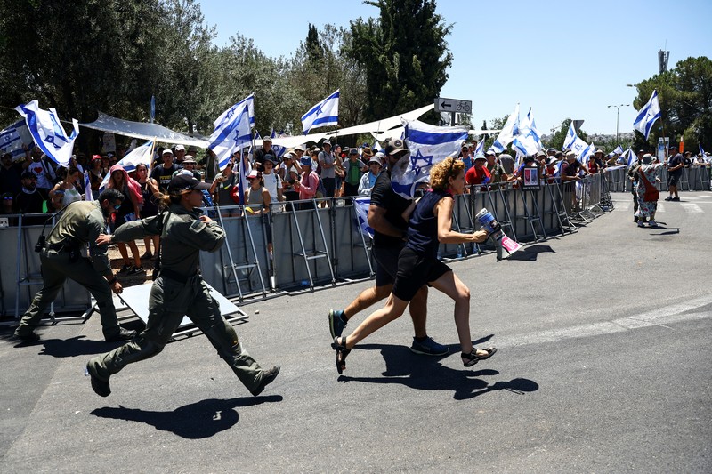 Polisi Israel melewati penghalang polisi selama demonstrasi menentang Perdana Menteri Israel Benjamin Netanyahu dan perombakan peradilan pemerintah koalisi nasionalisnya, di Yerusalem 24 Juli 2023. Polisi Israel melewati penghalang polisi selama demonstrasi menentang Perdana Menteri Israel Benjamin Netanyahu dan perombakan peradilan pemerintah koalisi nasionalisnya, di Yerusalem 24 Juli 2023. (REUTERS/Ronen Zvulun)