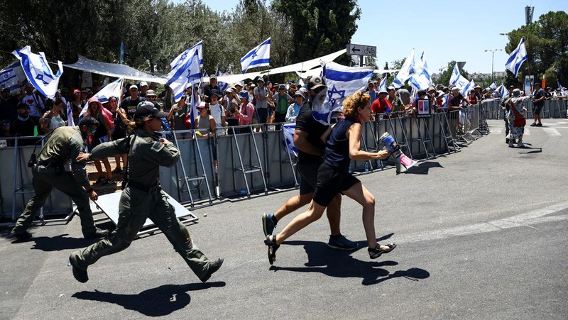 Polisi Israel melewati penghalang polisi selama demonstrasi menentang Perdana Menteri Israel Benjamin Netanyahu dan perombakan peradilan pemerintah koalisi nasionalisnya, di Yerusalem 24 Juli 2023. (REUTERS/Ronen Zvulun)
