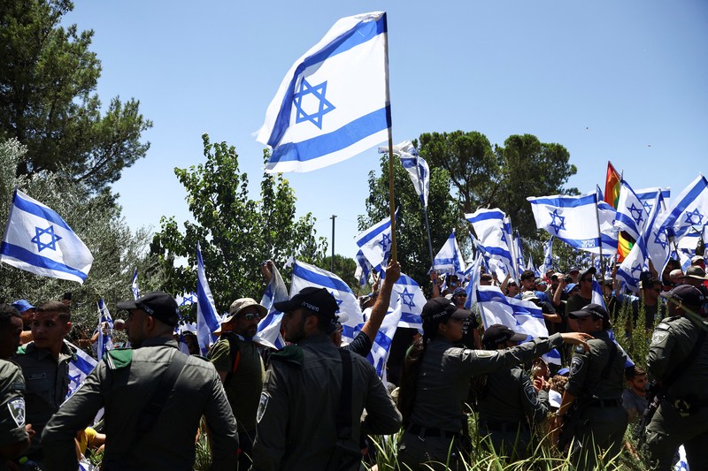 Polisi Israel melewati penghalang polisi selama demonstrasi menentang Perdana Menteri Israel Benjamin Netanyahu dan perombakan peradilan pemerintah koalisi nasionalisnya, di Yerusalem 24 Juli 2023. (REUTERS/Ronen Zvulun)