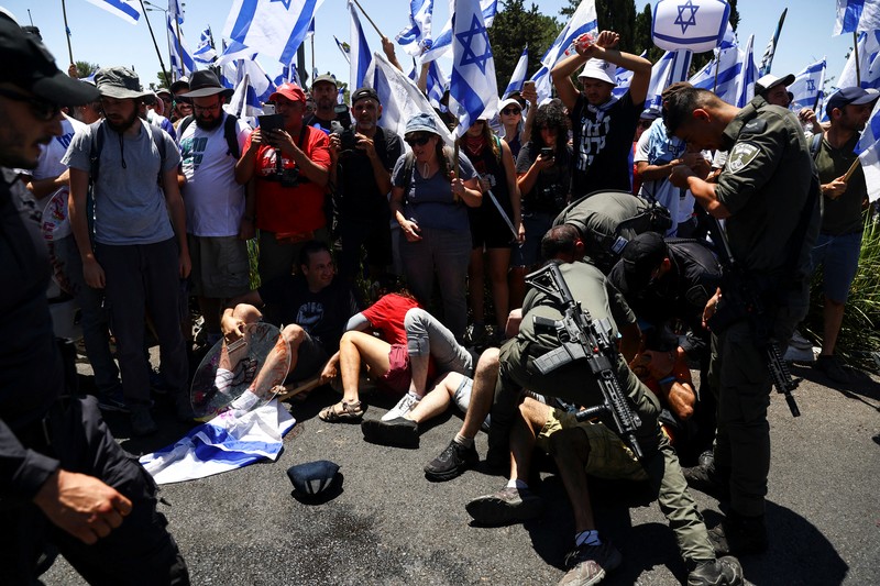 Polisi Israel melewati penghalang polisi selama demonstrasi menentang Perdana Menteri Israel Benjamin Netanyahu dan perombakan peradilan pemerintah koalisi nasionalisnya, di Yerusalem 24 Juli 2023. (REUTERS/Ronen Zvulun)