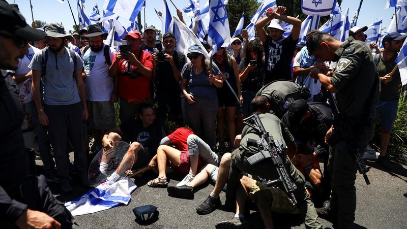 Polisi Israel melewati penghalang polisi selama demonstrasi menentang Perdana Menteri Israel Benjamin Netanyahu dan perombakan peradilan pemerintah koalisi nasionalisnya, di Yerusalem 24 Juli 2023. (REUTERS/Ronen Zvulun)