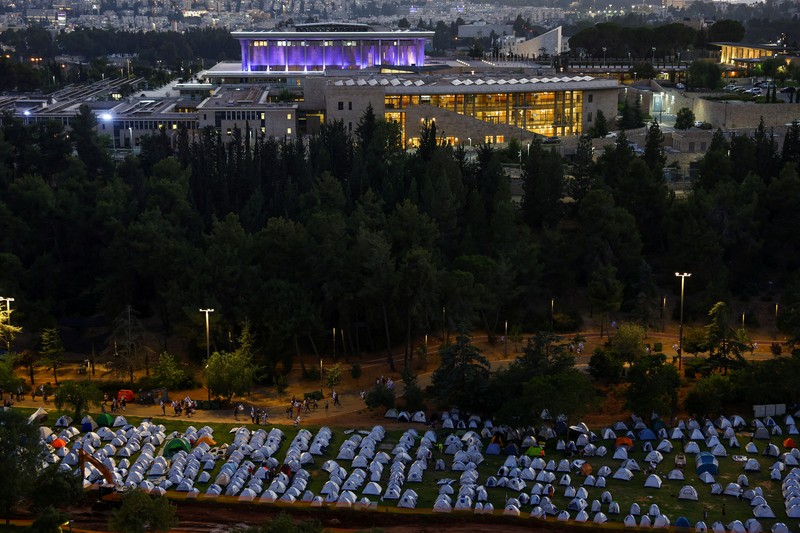 Ribuan demonstran Israel mendirikan tenda di luar Parlemen Israel, Knesset. Aksi tersebut dilakukan sebagai bagian dari protes terhadap rencana Perdana Menteri Israel Benjamin Netanyahu untuk merombak sistem peradilan yang kontroversial. (REUTERS/RONEN ZVULUN) Ribuan demonstran Israel mendirikan tenda di luar Parlemen Israel, Knesset. Aksi tersebut dilakukan sebagai bagian dari protes terhadap rencana Perdana Menteri Israel Benjamin Netanyahu untuk merombak sistem peradilan yang kontroversial. (REUTERS/RONEN ZVULUN)