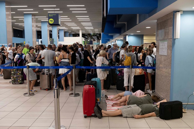 Wisatawan tidur sambil menunggu pesawat berangkat di bandara, setelah dievakuasi menyusul kebakaran hutan di pulau Rhodes, Yunani, (24/7/2023). (REUTERS/NICOLAS ECONOMOU) Wisatawan tidur sambil menunggu pesawat berangkat di bandara, setelah dievakuasi menyusul kebakaran hutan di pulau Rhodes, Yunani, (24/7/2023). (REUTERS/NICOLAS ECONOMOU)