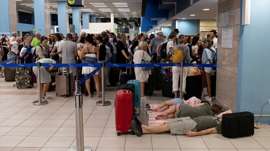 Wisatawan tidur sambil menunggu pesawat berangkat di bandara, setelah dievakuasi menyusul kebakaran hutan di pulau Rhodes, Yunani, (24/7/2023). (REUTERS/NICOLAS ECONOMOU)