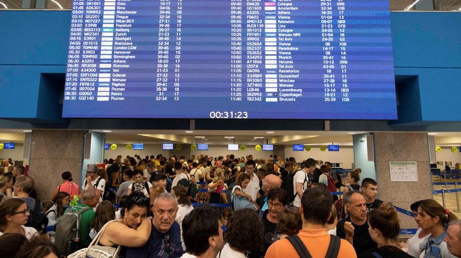 Wisatawan tidur sambil menunggu pesawat berangkat di bandara, setelah dievakuasi menyusul kebakaran hutan di pulau Rhodes, Yunani, (24/7/2023). (REUTERS/NICOLAS ECONOMOU)