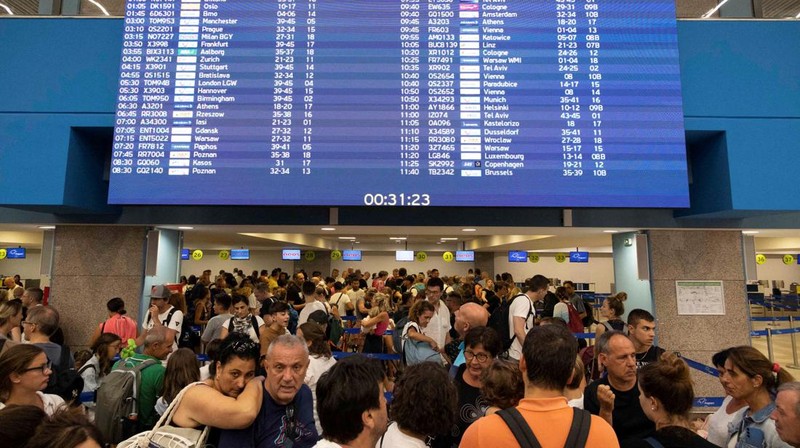 Wisatawan tidur sambil menunggu pesawat berangkat di bandara, setelah dievakuasi menyusul kebakaran hutan di pulau Rhodes, Yunani, (24/7/2023). (REUTERS/NICOLAS ECONOMOU)