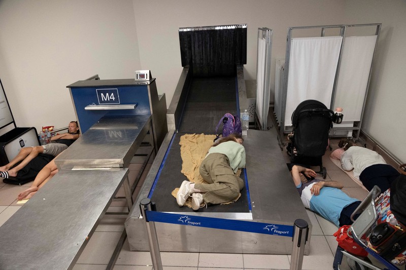 Wisatawan tidur sambil menunggu pesawat berangkat di bandara, setelah dievakuasi menyusul kebakaran hutan di pulau Rhodes, Yunani, (24/7/2023). (REUTERS/NICOLAS ECONOMOU) Wisatawan tidur sambil menunggu pesawat berangkat di bandara, setelah dievakuasi menyusul kebakaran hutan di pulau Rhodes, Yunani, (24/7/2023). (REUTERS/NICOLAS ECONOMOU)