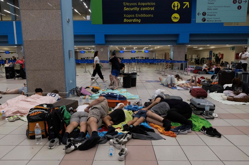 Wisatawan tidur sambil menunggu pesawat berangkat di bandara, setelah dievakuasi menyusul kebakaran hutan di pulau Rhodes, Yunani, (24/7/2023). (REUTERS/NICOLAS ECONOMOU) Wisatawan tidur sambil menunggu pesawat berangkat di bandara, setelah dievakuasi menyusul kebakaran hutan di pulau Rhodes, Yunani, (24/7/2023). (REUTERS/NICOLAS ECONOMOU)