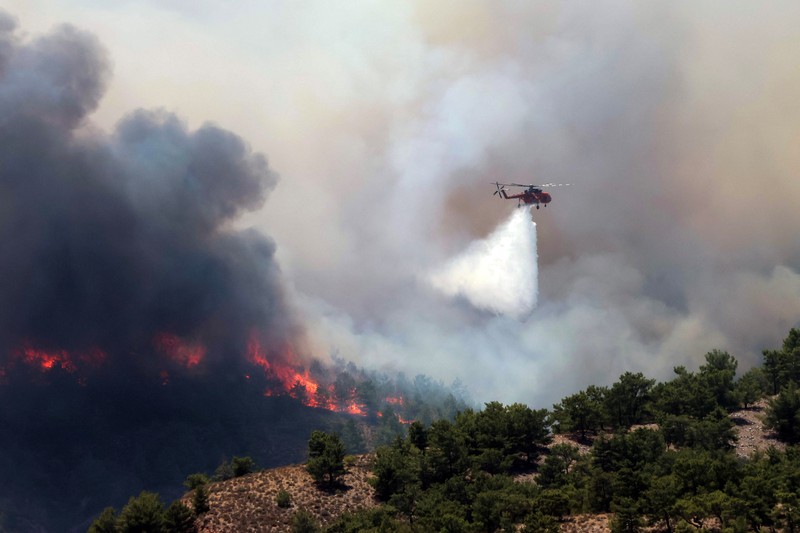 Petugas pemadam kebakaran Rumania memberikan air kepada kelinci yang diselamatkan dari kebakaran hutan di pulau Rhodes, Yunani, 24 Juli 2023. (Romanian Government's Department for Emergencies/Handout via REUTERS)