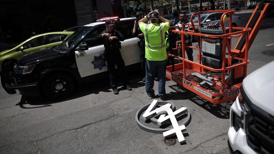Pekerja mulai membongkar papan tulisan Twitter yang berada di gedung kantor pusat perusahaan Twitter di pusat kota San Francisco, California, AS (24/7/2023). (REUTERS/CARLOS BARRIA)
