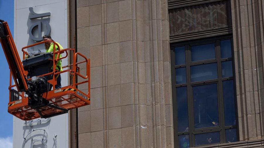 Pekerja mulai membongkar papan tulisan Twitter yang berada di gedung kantor pusat perusahaan Twitter di pusat kota San Francisco, California, AS (24/7/2023). (REUTERS/CARLOS BARRIA)