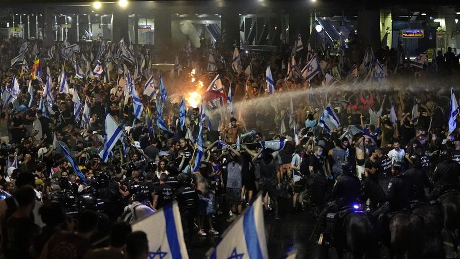 Polisi anti huru hara berusaha membersihkan demonstran dengan kanon air selama protes terhadap rencana pemerintah Netanyahu untuk merombak sistem peradilan, di Tel Aviv, Senin, 24 Juli 2023. Anggota parlemen Israel pada hari Senin menyetujui bagian penting dari rencana perpecahan Perdana Menteri Benjamin Netanyahu untuk membentuk kembali sistem peradilan negara meskipun protes besar-besaran telah mengungkap celah yang belum pernah terjadi sebelumnya dalam masyarakat Israel. (AP Photo/Ariel Schalit)