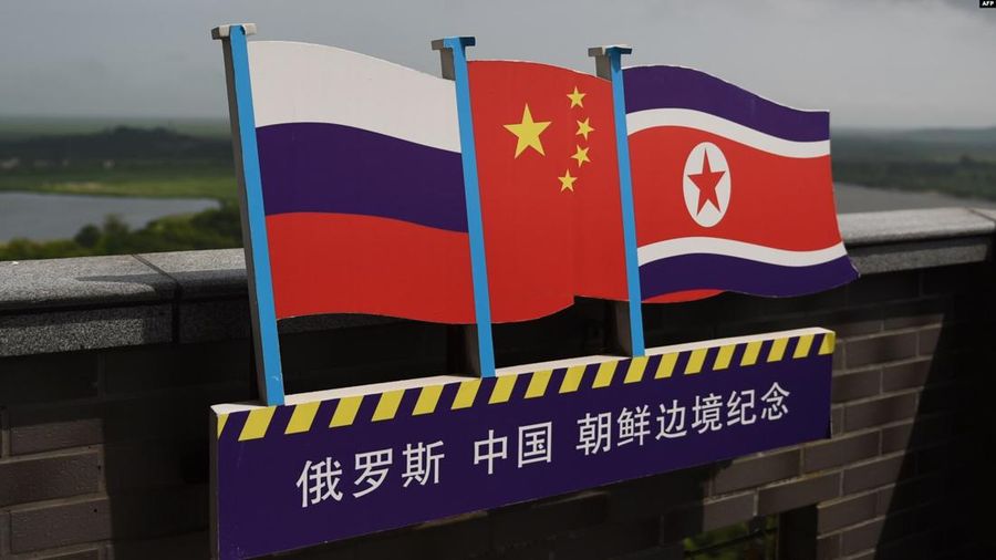 Ilustrasi Bendera Rusia (kiri), China (Tengah) dan Korea Utara (kanan). (GREG BAKER / AFP)