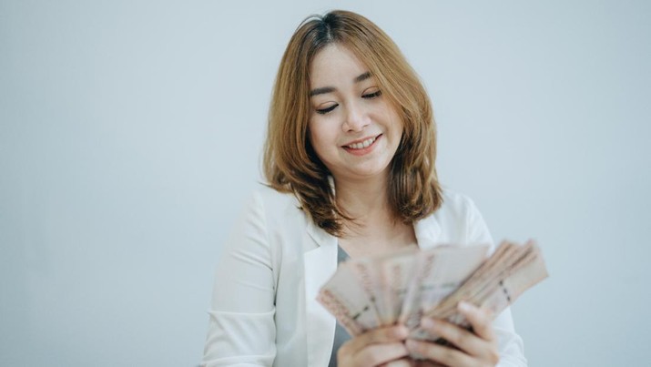 Young pretty woman is looking at cash banknotes, Thai Currency. Financial, profit, credit, cost, purchase, rich concept.