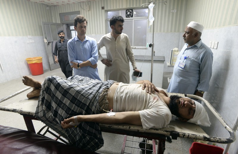 Seorang korban luka akibat ledakan bom dahsyat bersama kerabatnya setibanya di sebuah rumah sakit di Peshawar, Pakistan, Minggu, 30 Juli 2023. Sebuah bom mengoyak unjuk rasa pendukung ulama garis keras dan pemimpin politik di barat laut negara itu. Distrik Bajur yang berbatasan dengan Afghanistan pada Minggu, kata polisi dan pejabat kesehatan. (AP Photo/Muhammad Sajjad)
